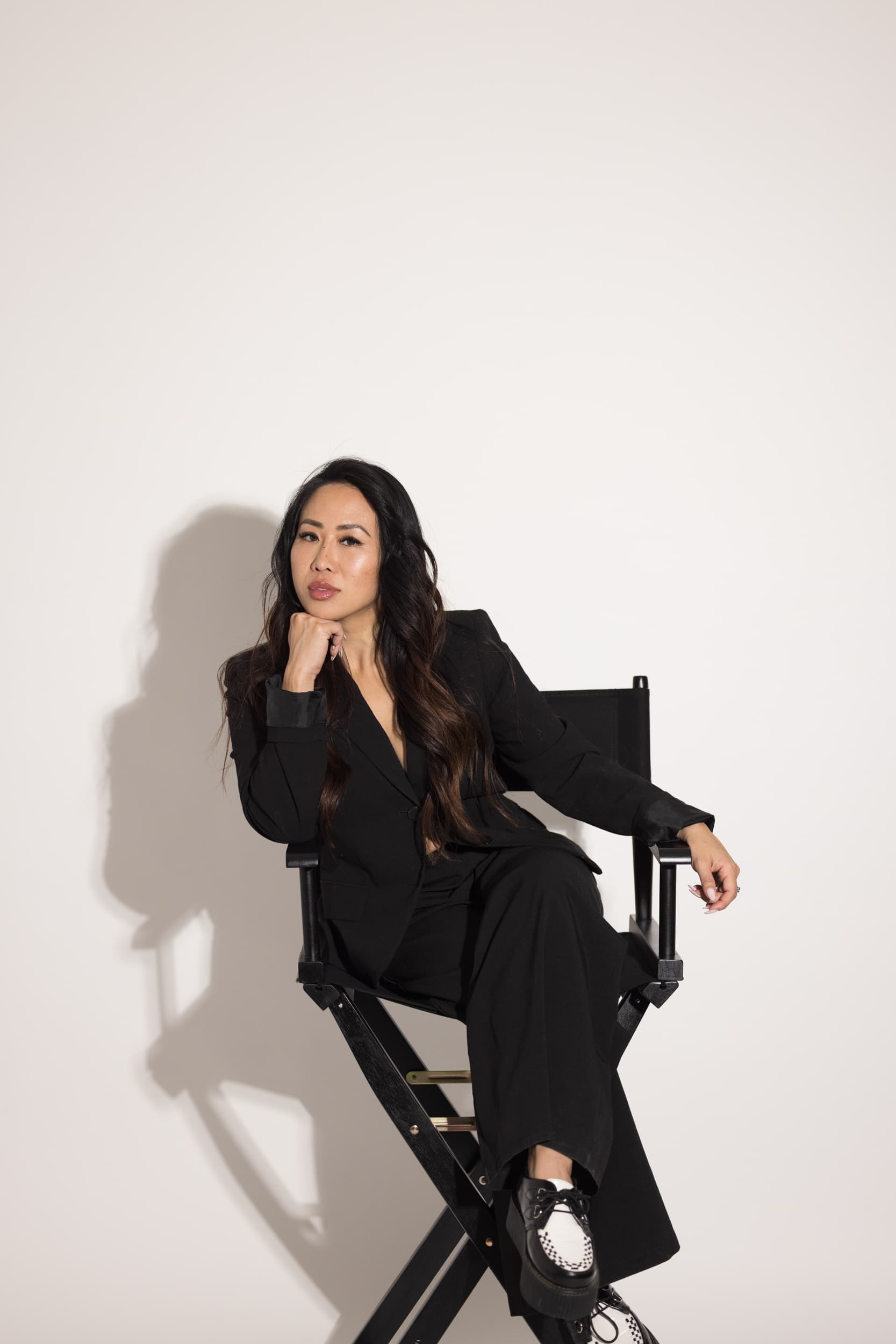 Lanna Dang seated in a director's chair, chin resting on her hand