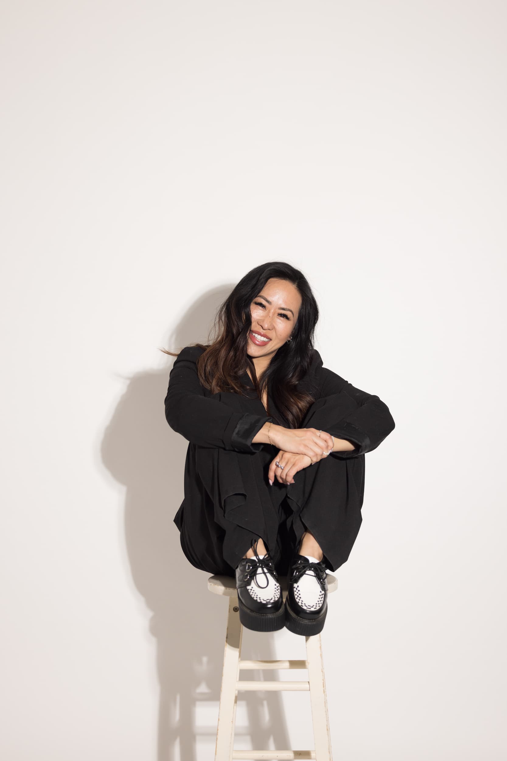 Lanna Dang seated on a stool, smiling